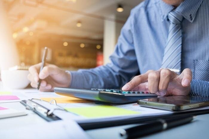 business finance man calculating budget numbers invoices and fi